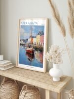 Aberaeron Wales travel poster in a simple white frame, displayed in a bright, modern living room.