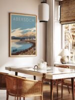 Abersoch Wales travel poster in a light wood frame, hanging on a living room wall above a sofa with a plant nearby.