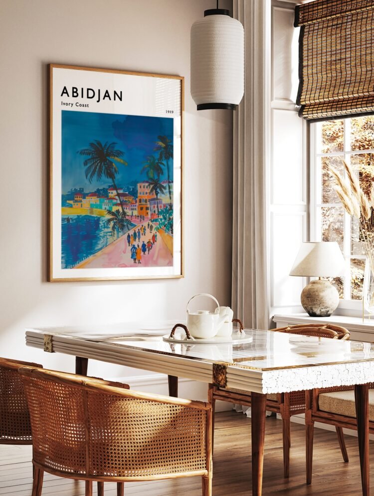 Abidjan Ivory Coast travel poster in a light wood frame, hanging in a bright, modern living room.