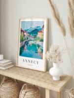 Annecy France travel poster in a modern black frame, displayed in a bright living room.