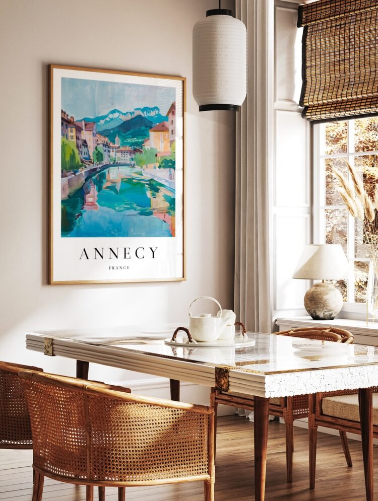 Annecy France watercolour poster in a light wood frame, hanging above a desk.