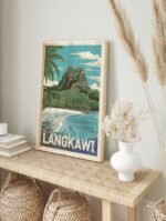 Framed Langkawi travel poster depicting a tropical beach and mountain, displayed in a bright, modern living space.