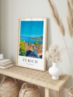Zurich Switzerland travel poster in a white frame displayed on a plain wall, showcasing the lakeside cityscape.